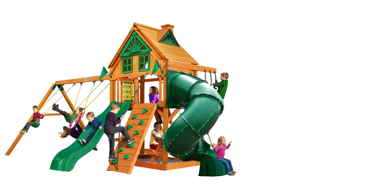 Seven children play on a wooden playground set with slides, swings, a climbing wall, a spiral slide, and a small clubhouse. The background is white, highlighting the playground structure and kids—perfect inspiration for your outdoor products shop.
